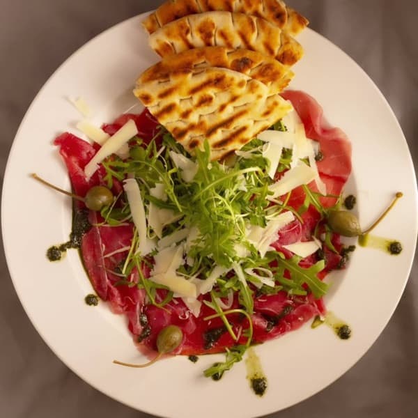 Beef carpaccio with shaved parmesan, capers and grilled flatbread