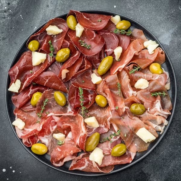 A charcuterie platter of cured meats, cheese and olives
