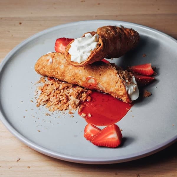 Cannoli filled with ricotta cream and served with strawberries