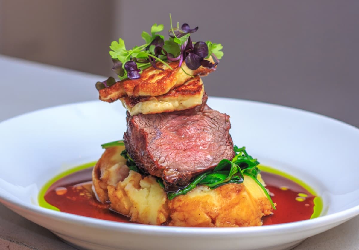A beef tenderloin course stacked with red wine jus
