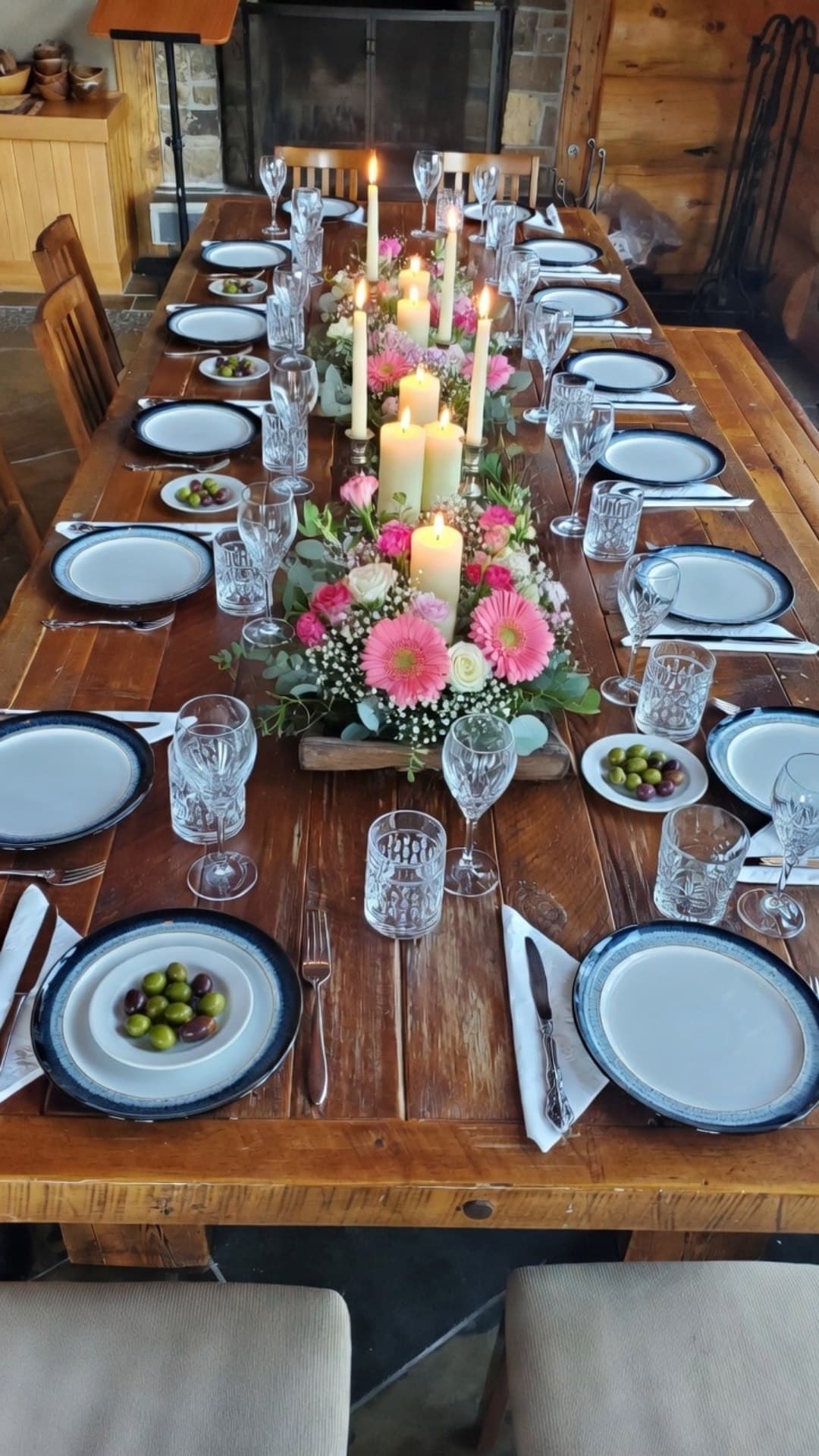 A long dining table laid with candles and flowers for a private dinner