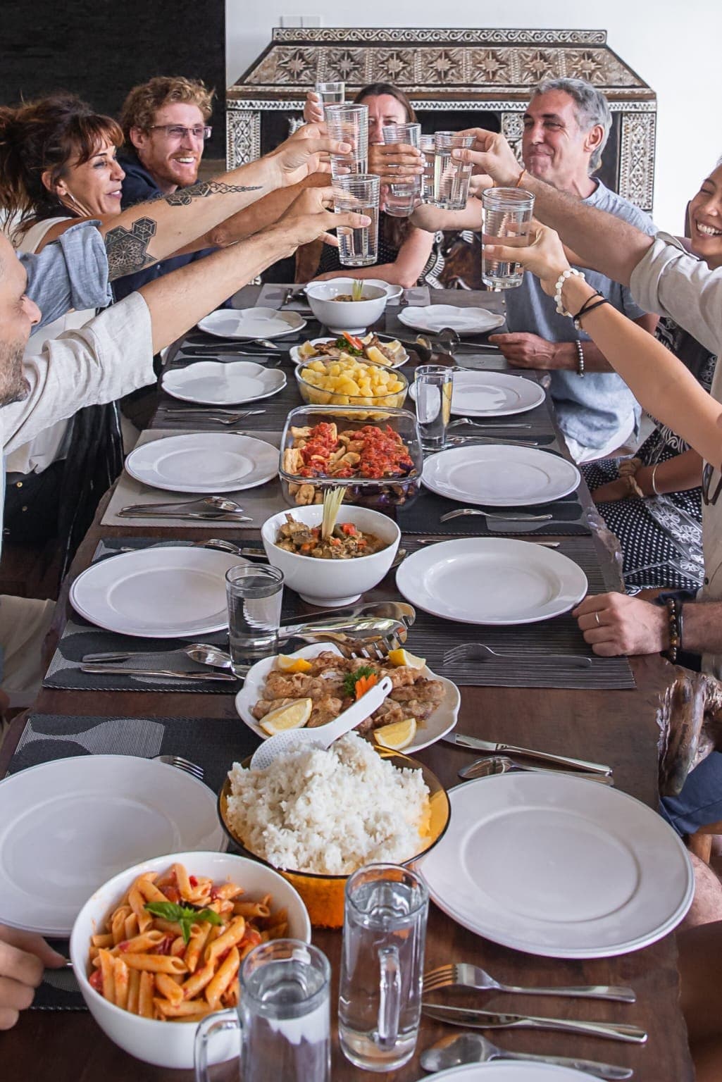 Guests raising a toast around a table of finished dishes