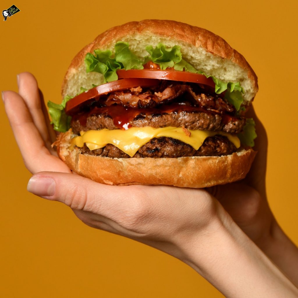 Woman-hands-hold-big-double-cheeseburger-burger-sandwich-with-beef 